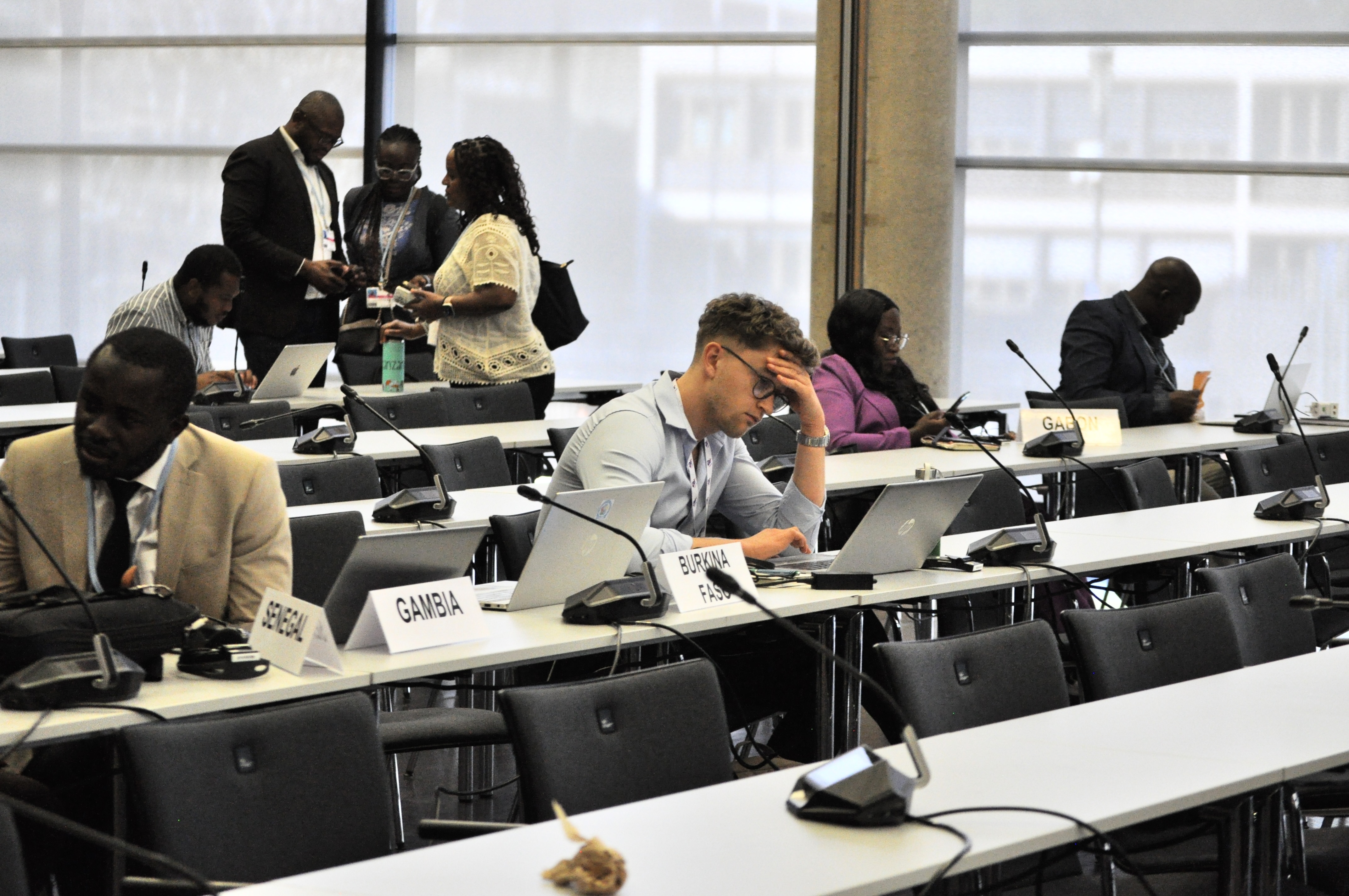 [15] At 6:00 PM, official negotiations have concluded for the day, but some negotiation blocs have closed-door strategy meetings that extend into the night. Here, delegates take a break before the evening meeting of African negotiators. This photo was taken moments before Observers were asked to leave the room. 