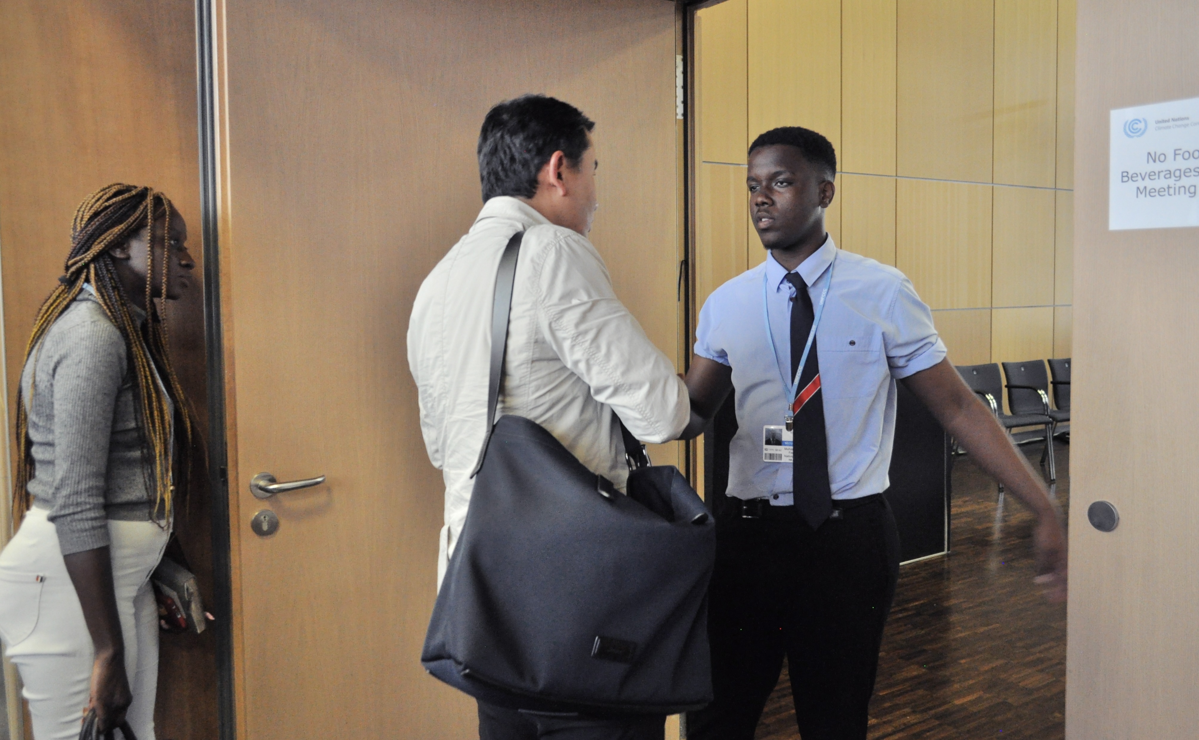 [6] At the entrance to a negotiation room, security requests identification from a UN Secretariat staffer.